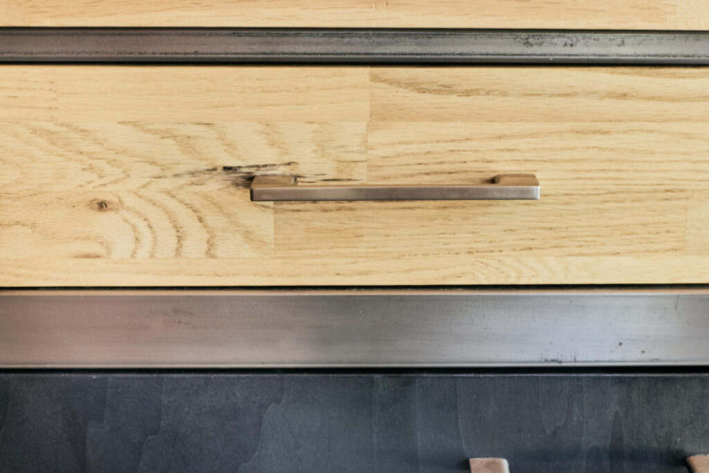 Близък план на дървено чекмедже с метална облицовка, изработено от Интериорен дизайн Studio28a.