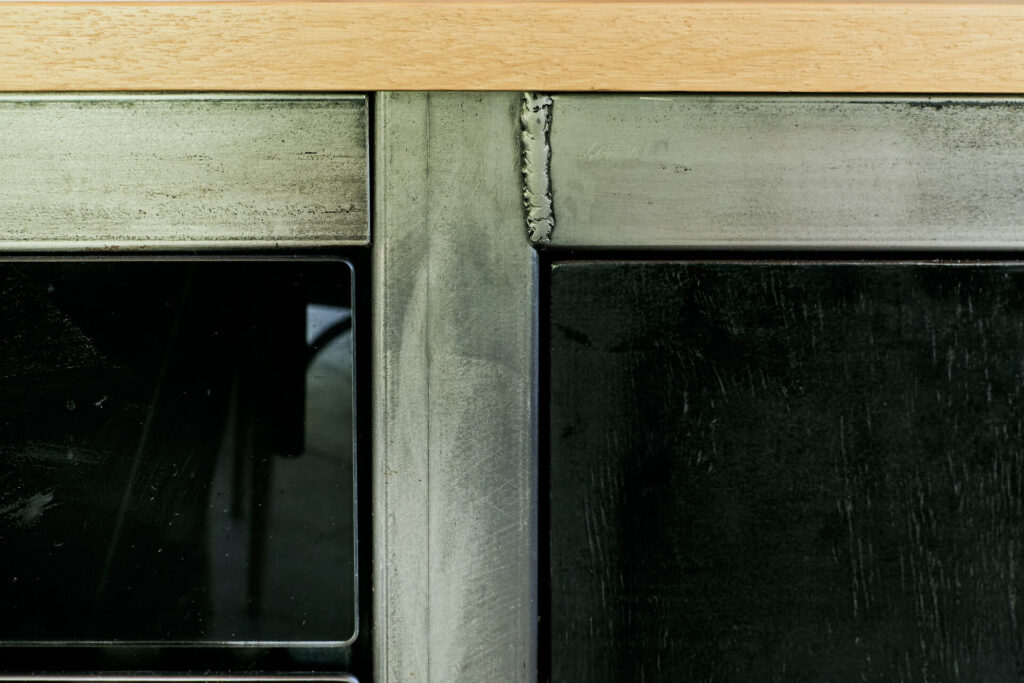 Близък план на прозорец с метална рамка и видим заваръчен шев, изработен от Интериорен дизайн Studio28a.