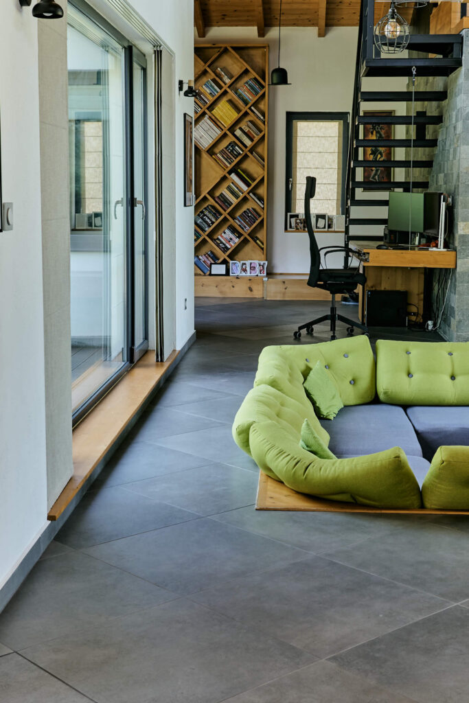 Модерно жилищно пространство от Интериорен дизайн Studio28a с потънал зелен диван, теракот и големи прозорци.