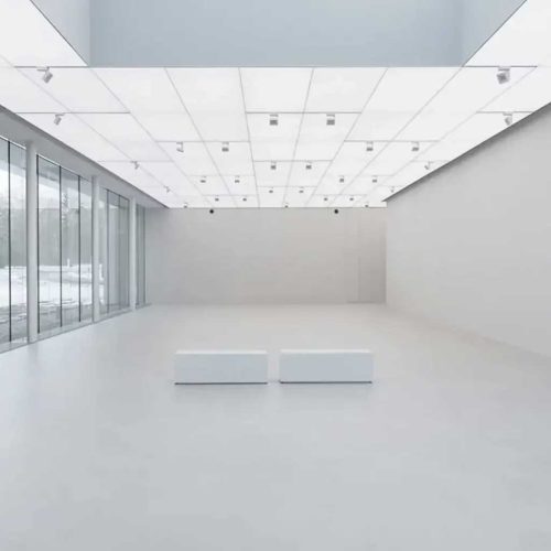 Минималистична галерия от Интериорен дизайн Studio28a с бели пейки, големи прозорци и осветен таван с решетъчни шарки.