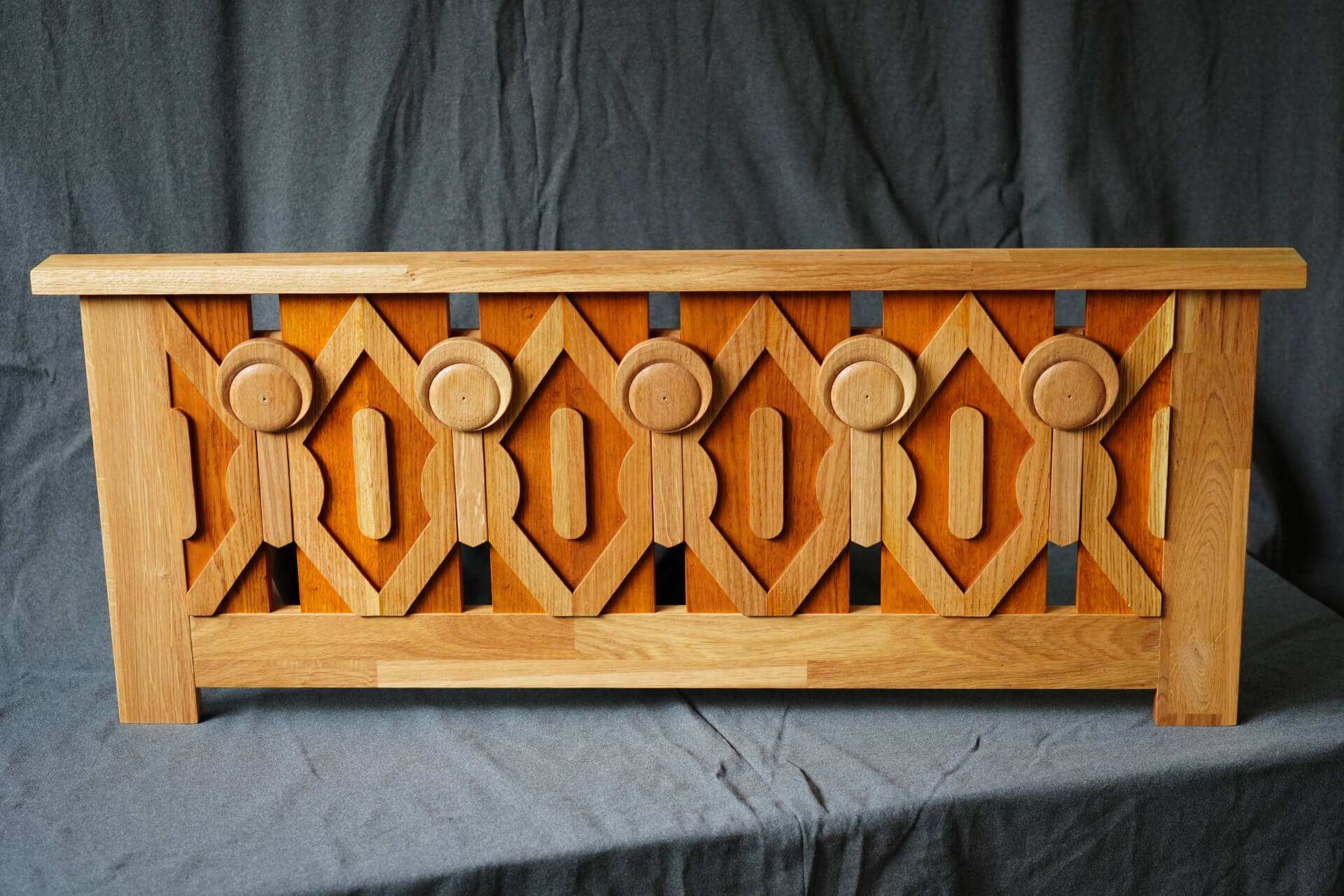 Дървен парапет със симетрични геометрични и кръгли прорези, изработен от Интериорен дизайн Studio28a.