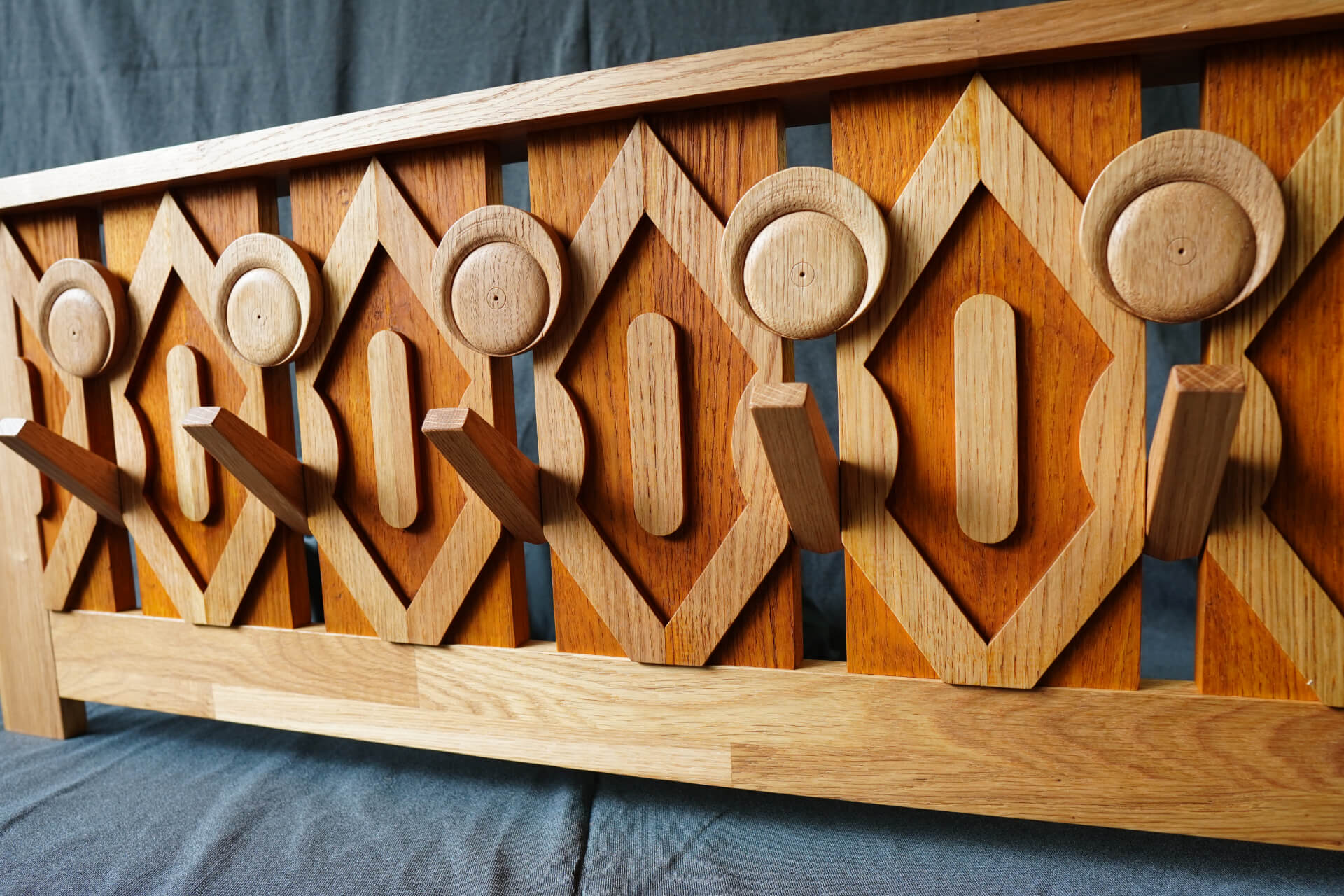 Дървена закачалка за дрехи с геометрични шарки, идеална за проекти на Интериорен дизайн Studio28a.