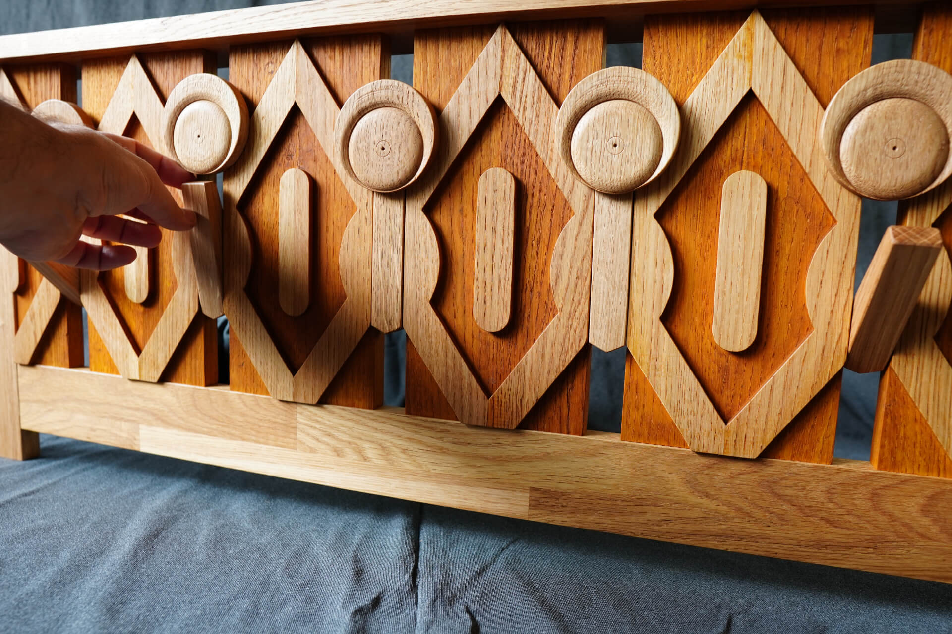 Ръката дърпа скрит дървен лост в сложно издълбано пано от Интериорен дизайн Studio28a.