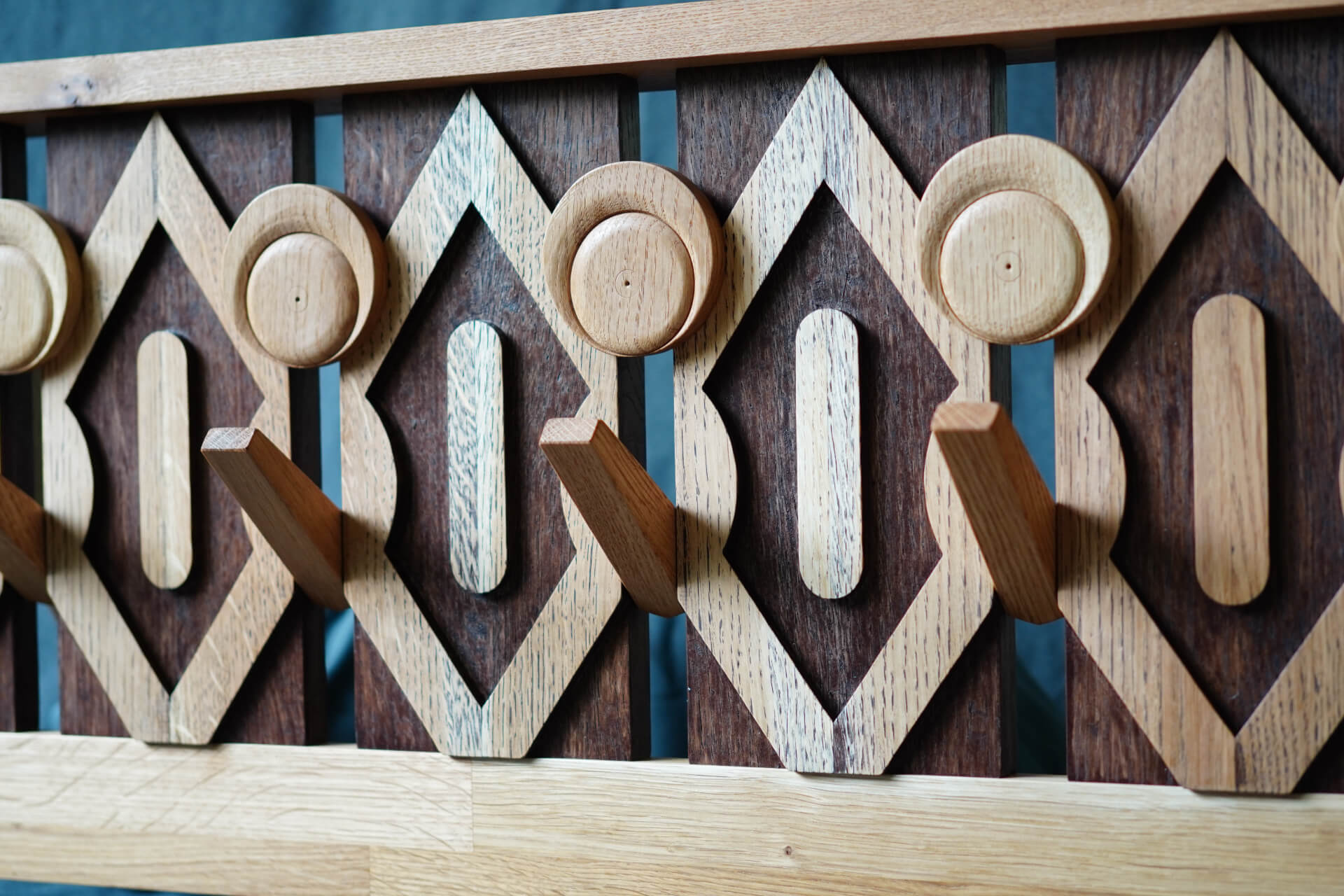 Близък план на дървена закачалка за дрехи с геометрични шарки, изработена от Интериорен дизайн Studio28a.