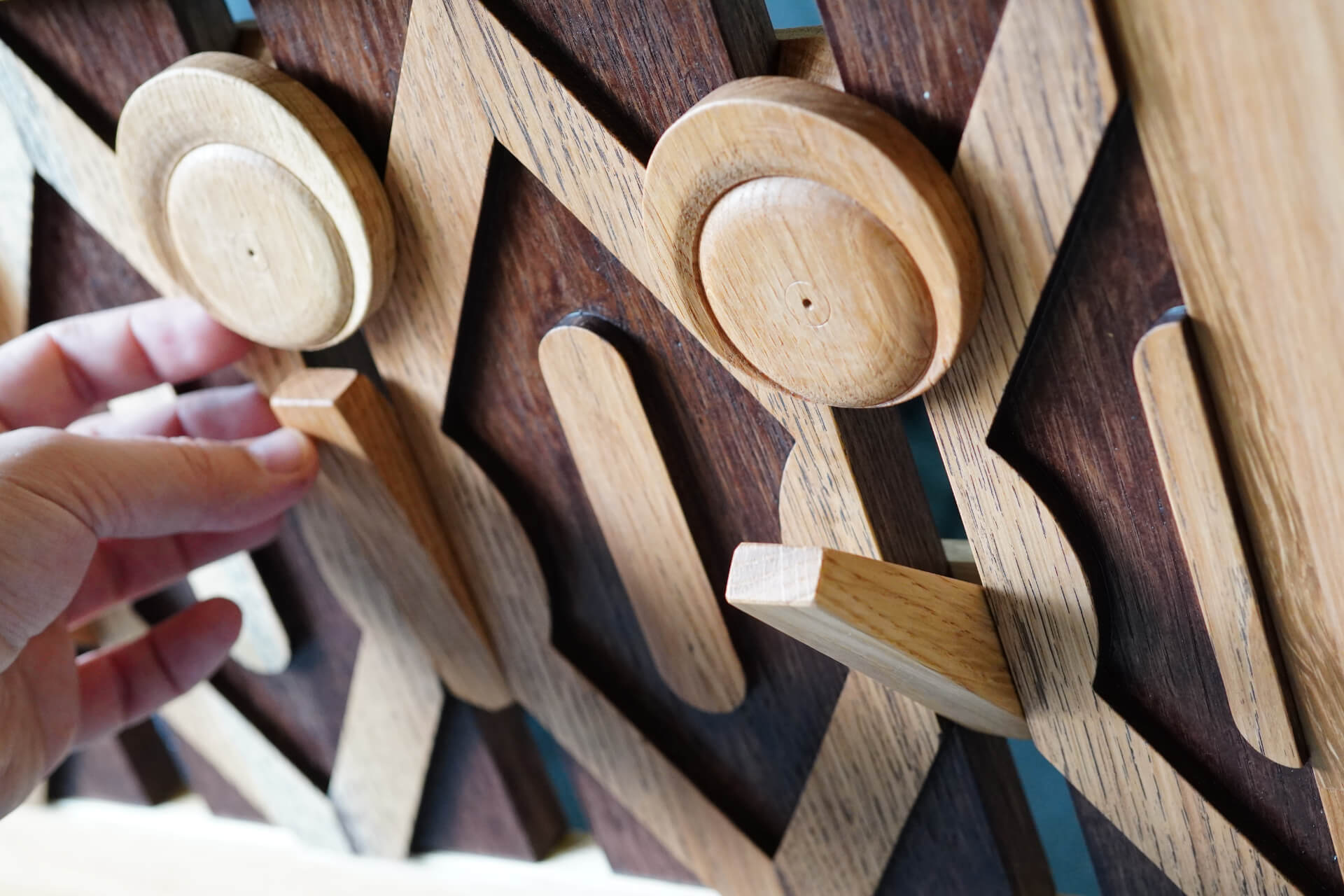 Ръка, която държи дървен предмет, изработен с внимание от Интериорен дизайн Studio28a.