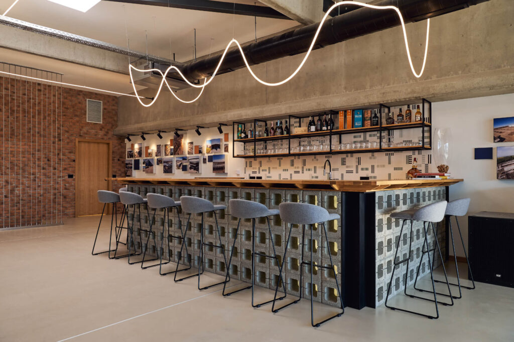 Модерен бар от Интериорен дизайн Studio28a с геометричен плот, сиви барстолове и стилно горно осветление.