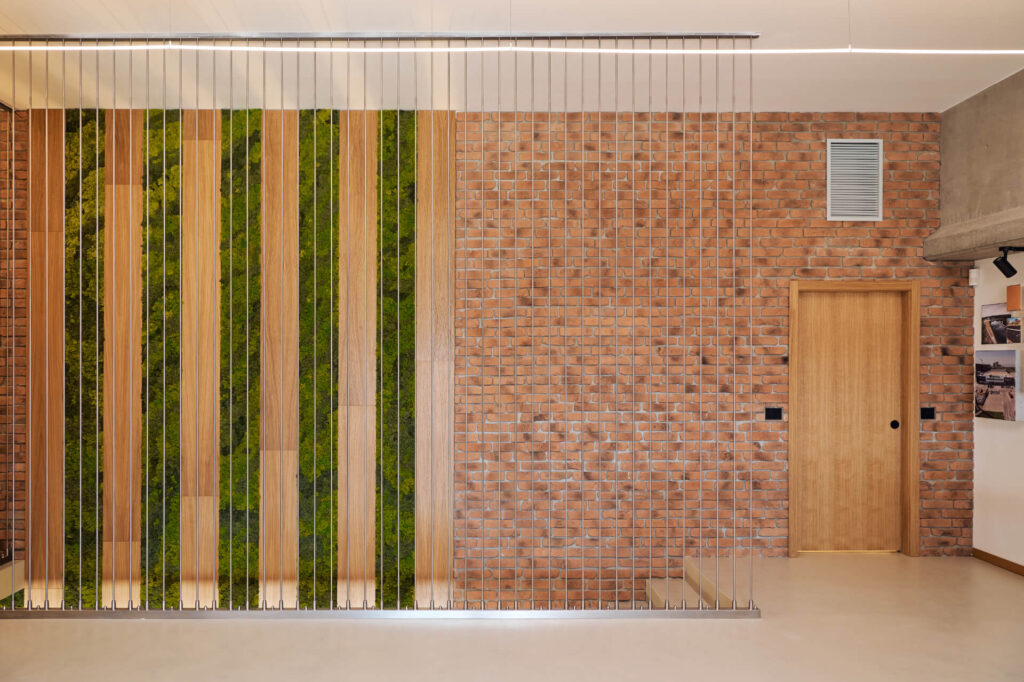 Модерен интериор от Интериорен дизайн Studio28a с тухлена стена, дървена врата, метална преграда и акценти от зелени панели.