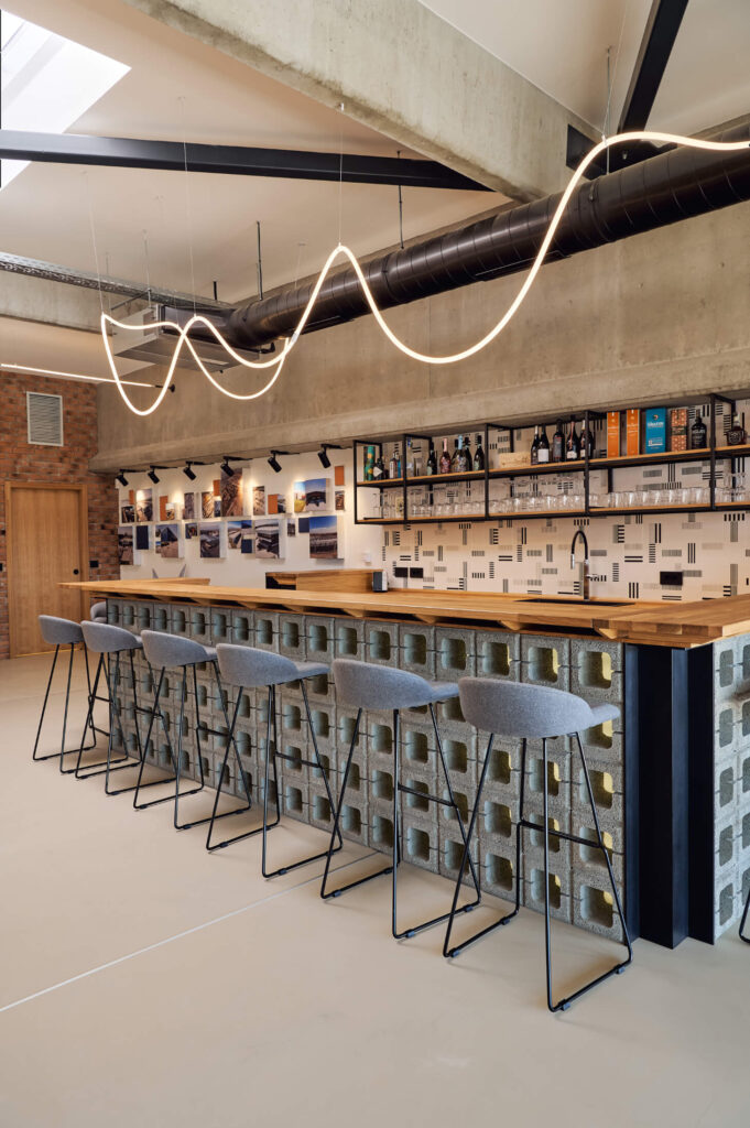 Модерен бар с високи табуретки, дървен плот и геометричен декор от Интериорен дизайн Studio28a.