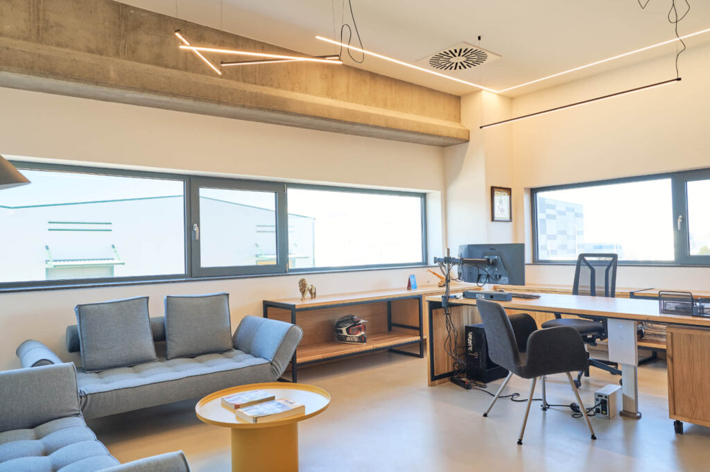 Модерен офис от Интериорен дизайн Studio28a с бюро, диван, рафтове и големи прозорци за естествена светлина.