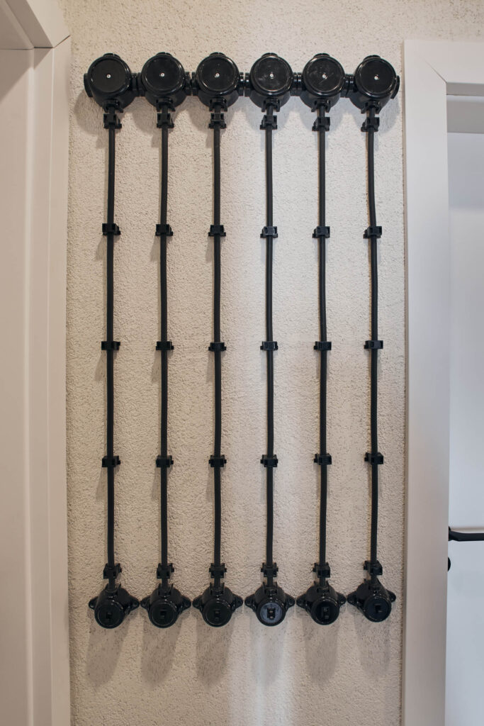 Шест вертикални черни тръби с кръгли фитинги придават индустриален характер на стената на Интериорен дизайн Studio28a.