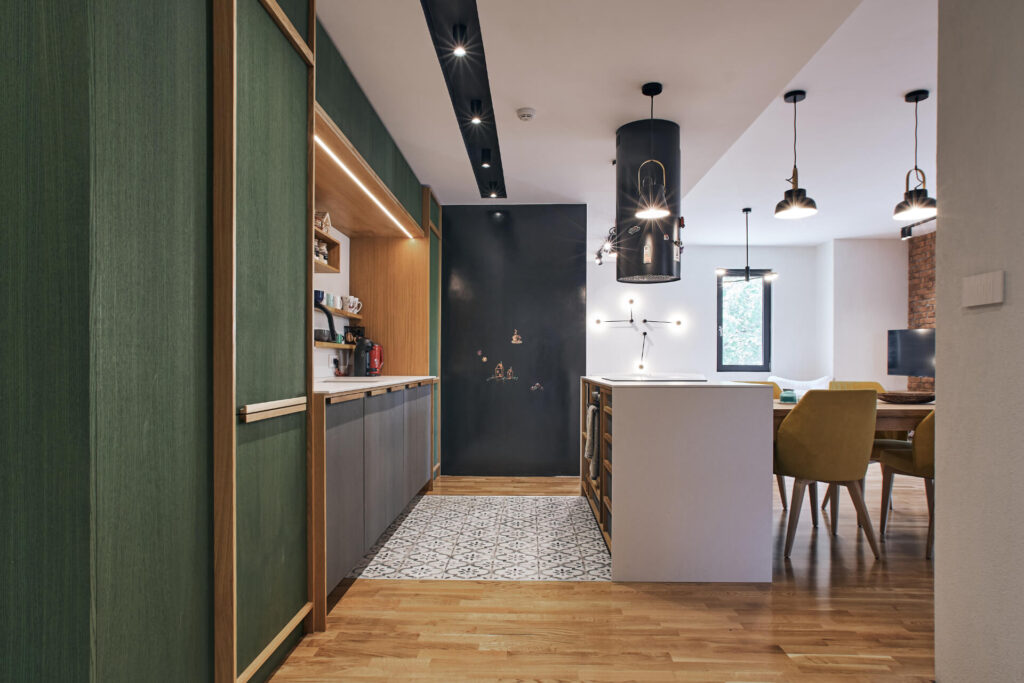 Модерна кухня от Интериорен дизайн Studio28a със зелени шкафове, шарени плочки и жълти столове в трапезарията.