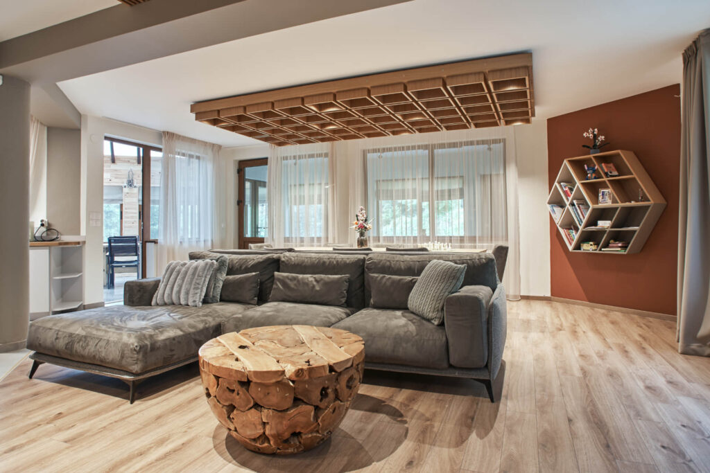 Модерна всекидневна от Интериорен дизайн Studio28a със сива секция, дървена масичка за кафе и шестоъгълна етажерка за книги.