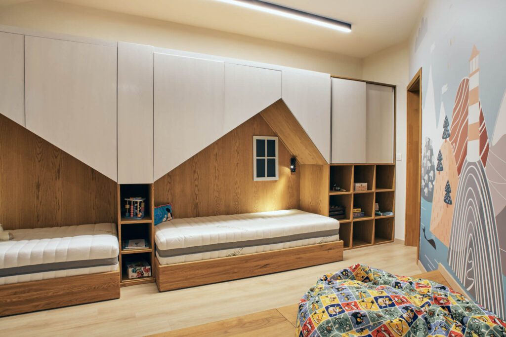 Модерна детска спалня от Интериорен дизайн Studio28a с две легла, дървени шкафове и стенопис на планина.