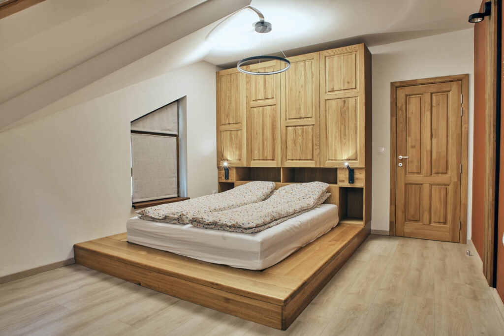 Минималистична спалня от Интериорен дизайн Studio28a с легло с дървена платформа, вградени шкафове и модерно осветление.