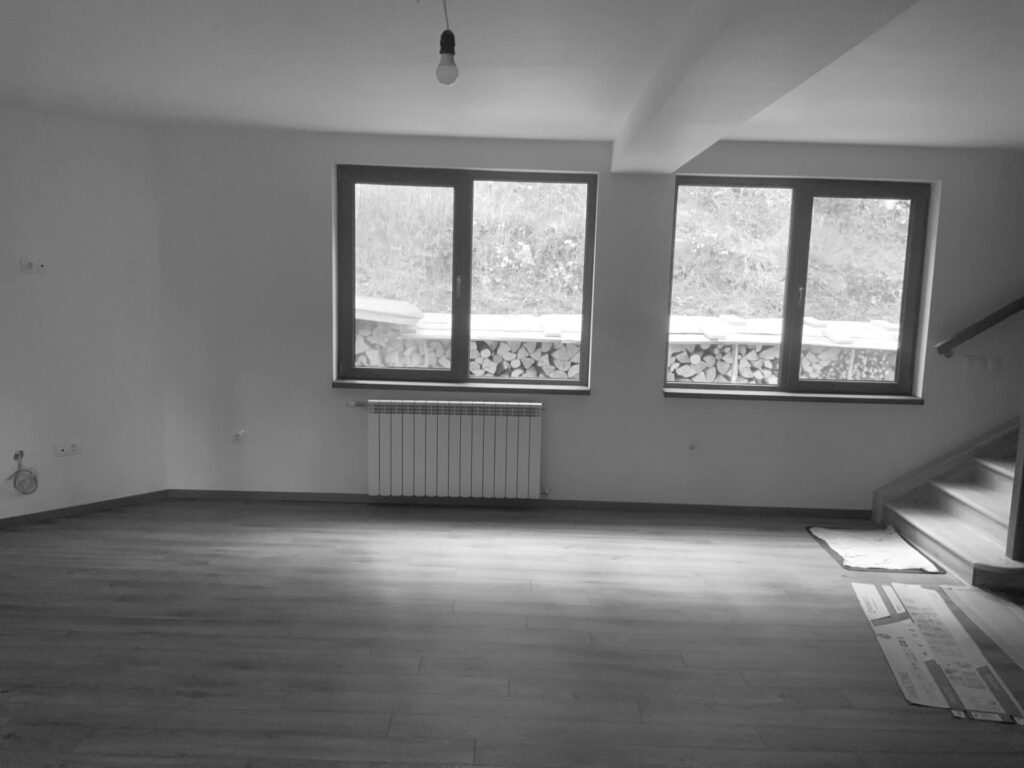 Празна стая с дървен под, големи прозорци и стълби - идеално платно за Интериорен дизайн Studio28a.