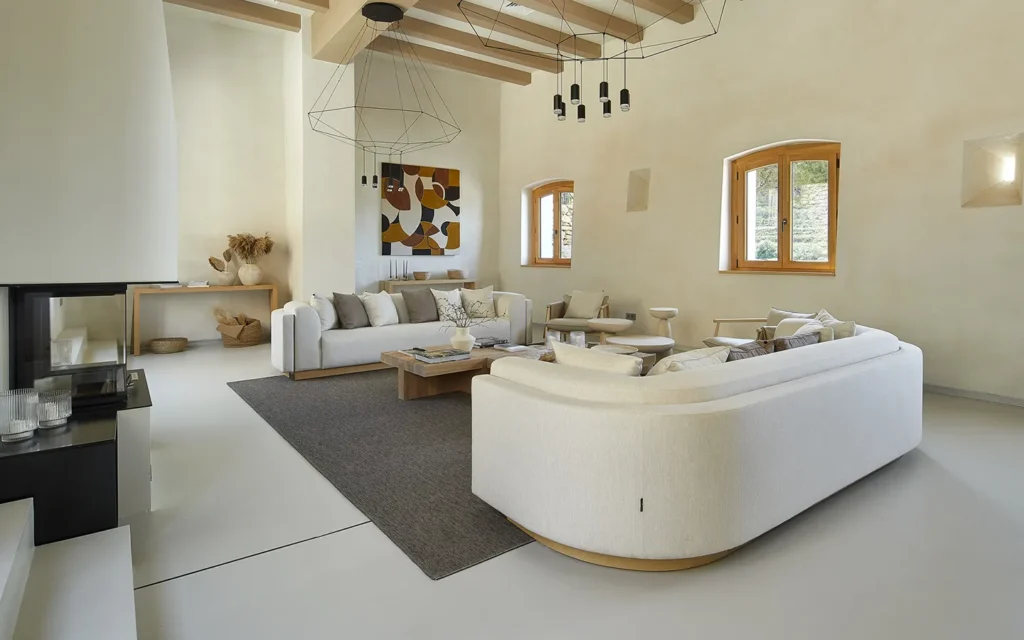 Модерната всекидневна на Интериорен дизайн Studio28a включва два бели дивана, сив килим и големи прозорци.