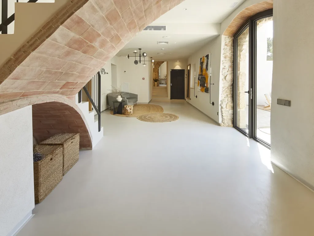 Модерен коридор от Интериорен дизайн Studio28a с извит тухлен таван, плетени кошници и слънчеви стъклени врати към вътрешния двор.